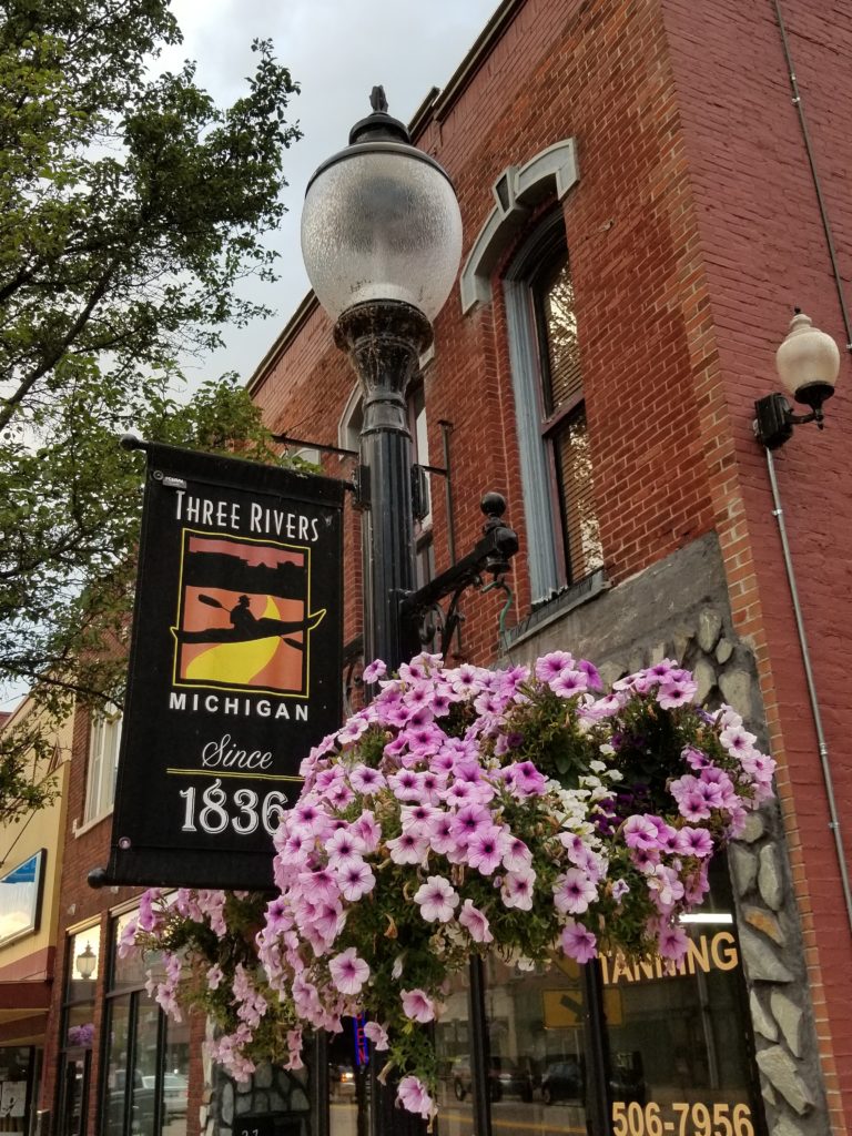 Street light pole, banner, and flowers, Three Rivers